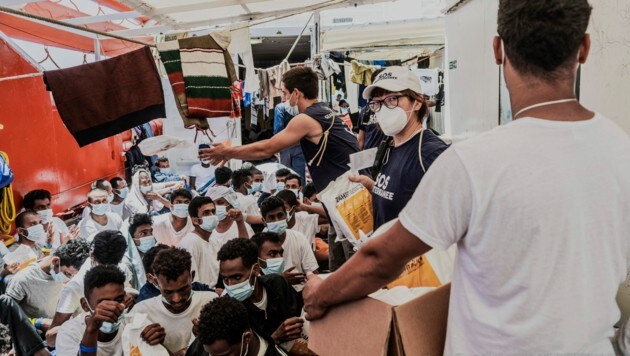 Crewmitglieder der „Ocean Viking“ verteilen im Juli 2021 Nahrungsmittel an gerettete Flüchtlinge. (Bild: Flavio Gasperini/AP)