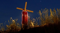 Ein Kleidchen hängt bei einer Autobahn in Kanada auf einem Holzkreuz. Es soll an die Kinder erinnern, die in den vergangenen Wochen in Hunderten Massengräbern gefunden wurden. (Bild: APA/AFP/Cole Burston)