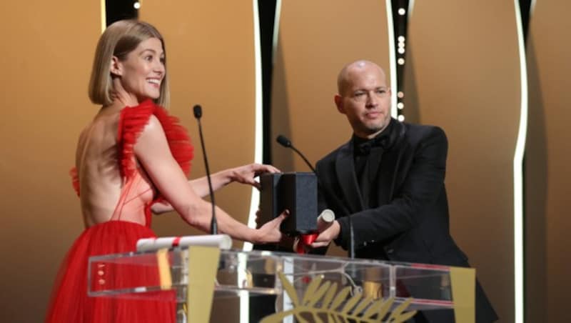 Rosamunde Pike überreicht dem israelischen Regisseur Nadal Lapid den Jury-Preis für den Film „Ha‘berech (Ahed‘s Knee)“. (Bild: APA/Photo by Valery HACHE / AFP)