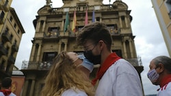 Dieses Pärchen geht in Pamplona (Spanien) auf Nummer sicher und trägt auch beim Kuss einen Mund-Nasen-Schutz (Bild: Associated Press)