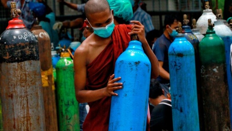 Ein buddhistischer Mönch in Myanmar der gerade dabei ist, einen Sauerstofftank für Covid-19-Patienten neu befüllen zu lassen. (Bild: AP)