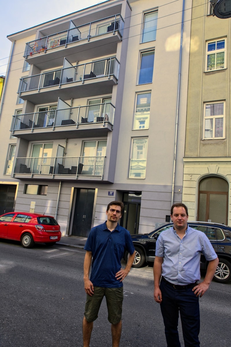 Viktor Schwabl und Georg Prack (Grüne) zeigen auf: „Alle 13 Wohnungen in der Senefeldergasse 23 werden als Ferienappartements angeboten.“ (Bild: Grüne Wien)