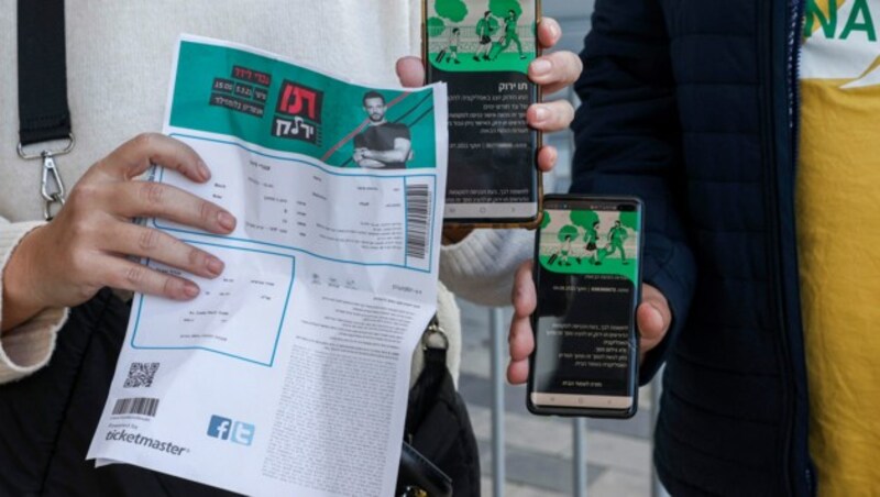 Besucher eines Konzerts in Israel zeigen ihre Eintrittskarte in Verbindung mit dem Grünen Pass vor. (Bild: AFP)