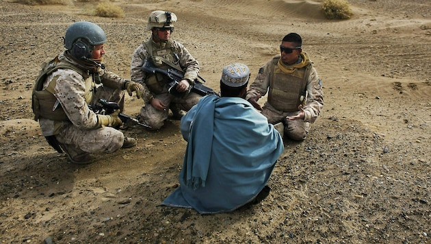 US-Soldaten befragen auf dieser Archivaufnahme aus dem Jahr 2009 einen Einheimischen mithilfe eines afghanischen Dolmetschers. (Bild: AP)
