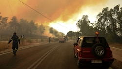 Griechische Feuerwehrmänner bekämpfen die schweren Waldbrände in Labiri in der Nähe von Patras. (Bild: AFP)