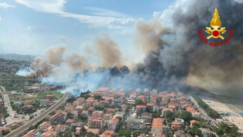 Im italienischen Badeort Pescara musste über 100 Menschen aus ihren Häusern in Sicherheit gebracht werden. Auf dieser Luftaufnahme der Feuerwehr sieht man, wie sich die Flammen durch das Land fressen. (Bild: AP)