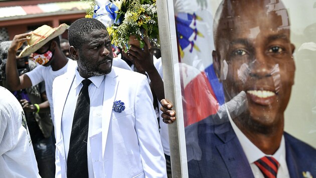 Diese Demonstranten fordern Gerechtigkeit für ihren getöteten Präsidenten Jovenel Moïse (rechts im Bild). (Bild: AP)