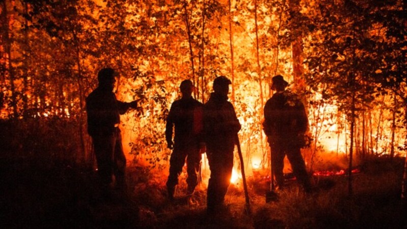 Feuerwehrleute stehen im Westen von Jakutsk einem scheinbar übermächtigen Gegener gegenüber. (Bild: Associated Press)