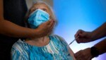 Diese 86-Jährige hat bereits drei Dosen Corona-Impfstoff im Körper. (Bild: AP)