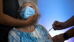 Diese 86-Jährige hat bereits drei Dosen Corona-Impfstoff im Körper. (Bild: AP)
