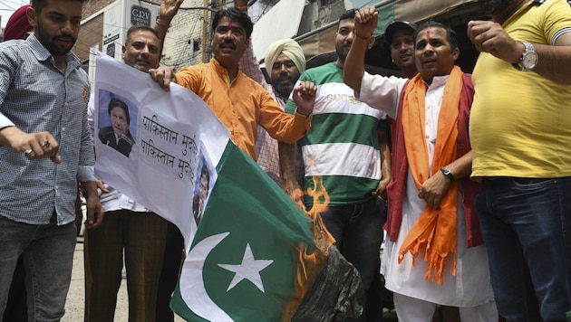 Aktivisten zünden nach dem Angriff auf den Hindu-Tempel aus Protest eine pakistanische Flagge an. (Bild: AFP )