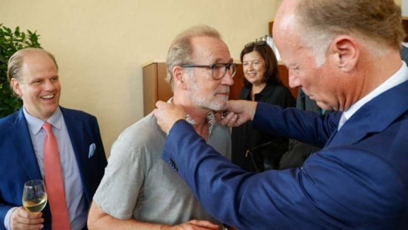 Peter Lohmeyer lässt sich ein Diamanten Collier anlegen. Florian Köchert gefällt der Look. (Bild: Tschepp Markus)