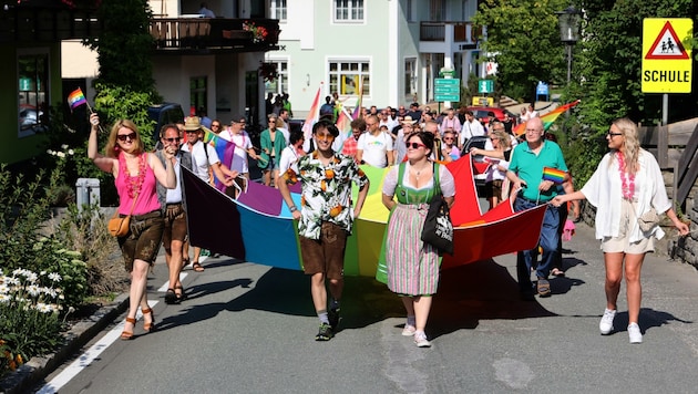 Sie spazierten am Samstag mit einer 12 Meter langen Regenbogenfahne durch den Ort. (Bild: Roland Hölzl)
