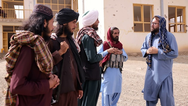 „Bild“-Redakteur Paul Ronzheimer (in Blau) bei Gesprächen mit Taliban-Kämpfern. (Bild: Paul Ronzheimer)