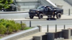 Vorerst blieb unklar, ob der Mann in seinem Fahrzeug - im BIld ist ein Sprengstoffroboter der Behörden gerade neben dem Fahrzeug zu sehen - tatsächlich - wie von ihm behauptet - einen Sprengsatz gehabt hat. (Bild: AP)