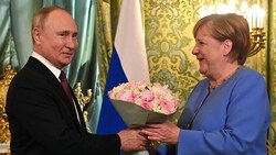 Der russische Langzeitpräsident überreichte der Bald-Nicht-Mehr-Kanzlerin bei ihrem letzten Besuch in Moskau Blumen. (Bild: APA/AFP/SPUTNIK/Evgeny ODINOKOV)