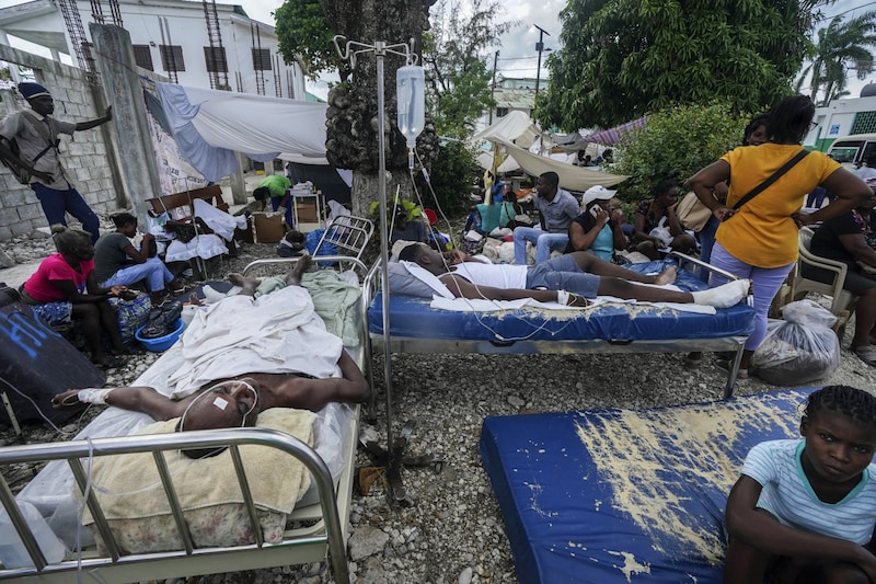 Verletzte Menschen müssen teilweise noch immer direkt auf der Straße behandelt werden. (Bild: AP Photo/Fernando Llano)