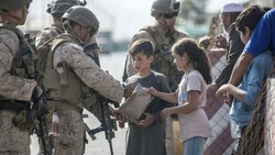 Bilder des Mitgefühls: Soldaten kümmern sich um Kinder auf dem Flughafen Kabul. (Bild: AP)