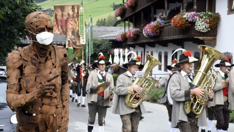 Corona ist allgegenwärtig. Die Musik marschierte an der „Masken-Skulptur“ vorbei. (Bild: Andreas Fischer)