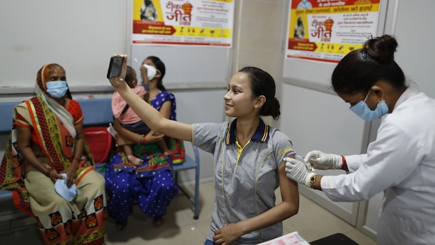 Eine Inderin hält den Moment ihrer Impfung mit einem Selfie fest. (Bild: Associated Press)