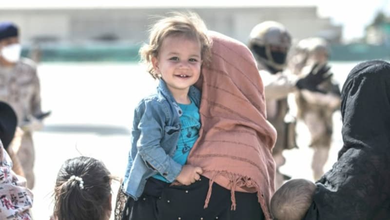 Kurz vor dem Evakuierungsflug in Sicherheit lächelt dieses afghanische Mädchen in die Kamera eines Fotografen. (Bild: AFP)