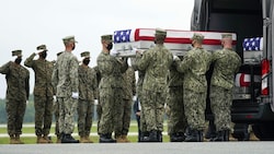 Die Särge wurden am Militärflughafen in Lastwagen umgeladen. (Bild: AP)