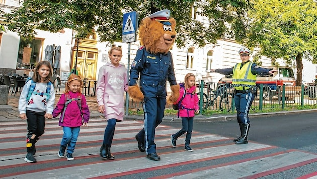 Das Polizeimaskottchen begleitet die Kinder über die Straße. (Bild: LPD Wien)
