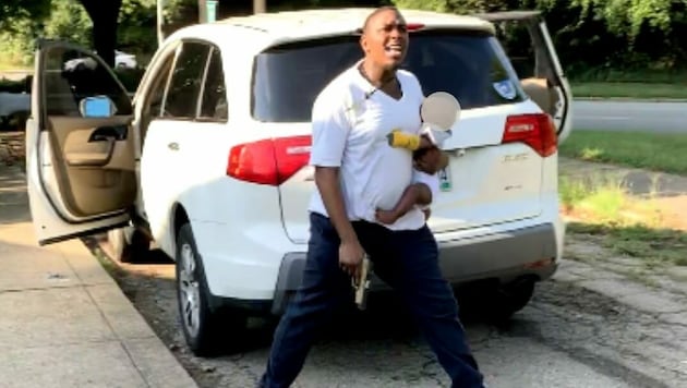 Die Polizei von Cincinnati zeigt Fotos eines Mannes mit Baby im Arm und einer Pistole in der Hand, die aus einer Überwachungskamera stammen. (Bild: Cincinnati Police Department)