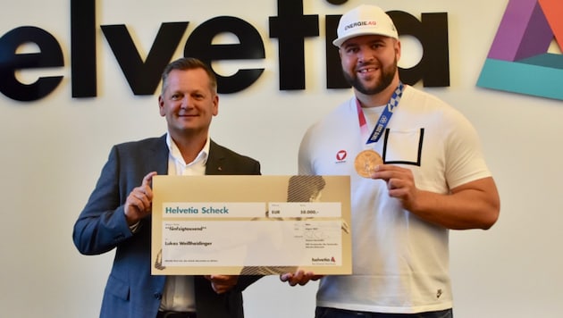 „Helvetia“-CEO Thomas Neusiedler überreicht Lukas Weißhaidinger den Scheck in Höhe 50.000 Euro. (Bild: Olaf Brockmann)