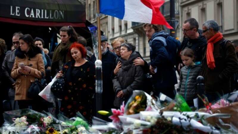 Auf diesem Foto aus dem November 2015 gedenken Menschen der Opfer des Terroranschlags von Paris. (Bild: AP)