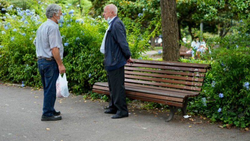 Zwei Männer in einem Park in der portugiesischen Hauptstadt Lissabon. Seit Montag gilt keine Maskenpflicht mehr im Freien. (Bild: AP)