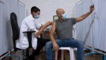 Selfie bei der Booster-Impfung: Ein Mann erhält in Israel die dritte Dosis Pfizer-Vakzin. (Bild: AP)