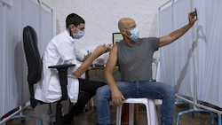 Selfie bei der Booster-Impfung: Ein Mann erhält in Israel die dritte Dosis Pfizer-Vakzin. (Bild: AP)