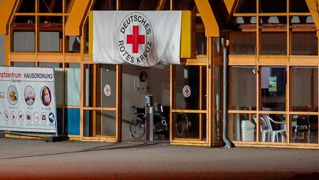 Eine Rot-Kreuz-Fahne hängt über dem Eingang zum Impfzentrum in Treuen. Im sächsischen Vogtlandkreis hat es einen Brandanschlag auf ein Impfzentrum gegeben. (Bild: APA/dpa-Zentralbild/B&S)
