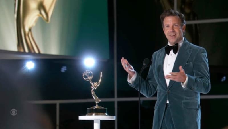 Jason Sudeikis mit seinem Emmy für „Ted Lasso“ auf der Bühne der Emmy Awards (Bild: APA/Television Academy via AP)