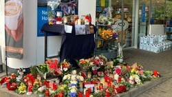 Blumen und Kerzen sind vor jener Tankstelle in Idar-Oberstein aufgestellt, in der ein 20 Jahre alter Mitarbeiter erschossen wurde, weil er auf die Einhaltung der Corona-Maßnahmen hingewiesen hatte. (Bild: APA/dpa/Birgit Reichert)