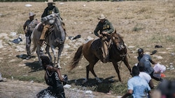 Berittene US-Grenzpolizisten treiben haitianische Flüchtlinge zurück in den Rio Grande. (Bild: AP)