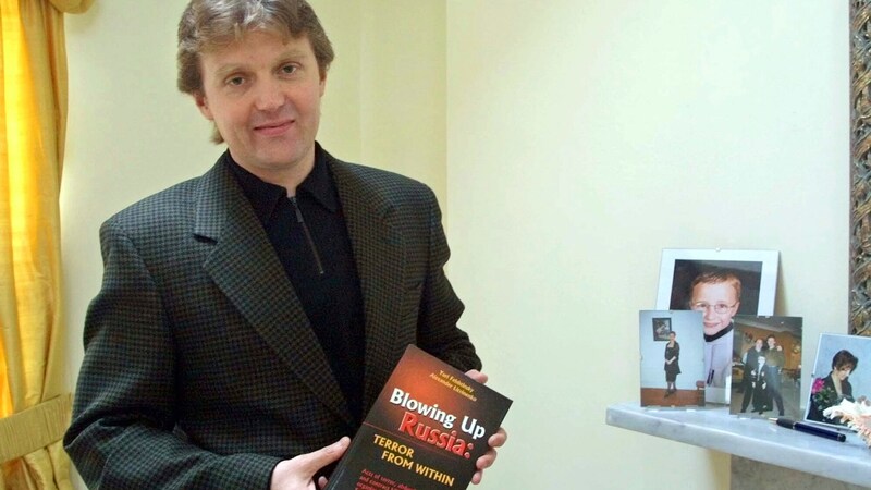 Alexander Litvinenko 2002 yılında Londra'da Kremlin'i eleştiren kitabıyla birlikte (Bild: AP)