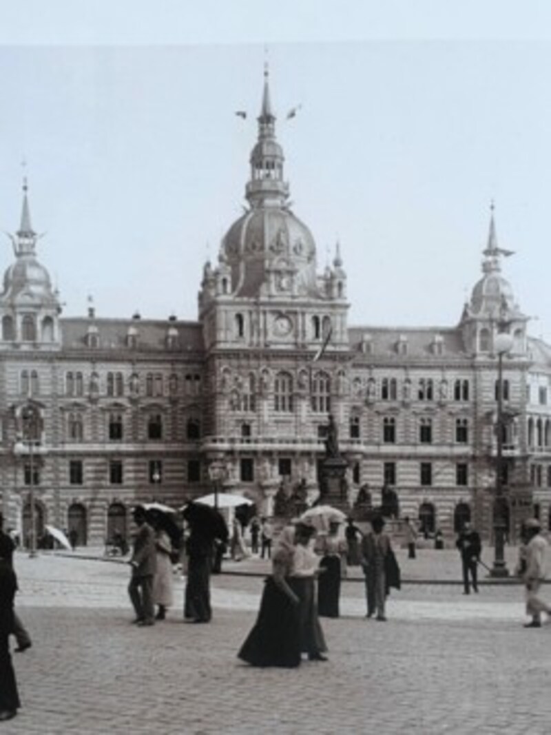 Mit Schirm, Charme - und Zylinder: Feine Damen und Herren mit Zylinder flanieren am Grazer Hauptplatz. (Bild: Aus dem Buch "Lebendige Altstadt", Stocker Verlag)