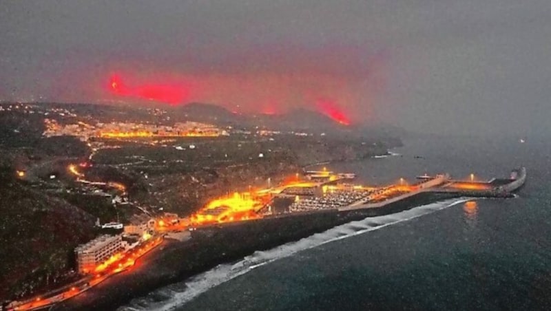 Lava is seen and smoke rises following the eruption of a volcano, in the Port of Tazacorte, on the Canary Island of La Palma, Spain, September 28, 2021. Picture taken with a drone. REUTERS/Nacho Doce (Bild: REUTERS)