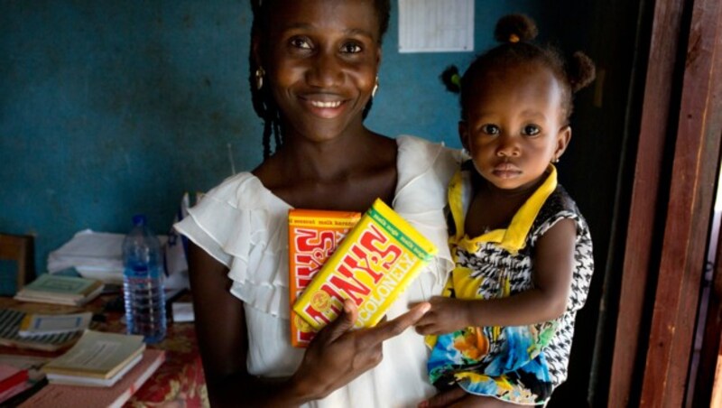 Eine Kakaobäuerin in Ghana hält eine Tafel Tony’s Chocolonely in der Hand. Das Unternehmen hat es sich zum Ziel gesetzt, Schokolade zu 100 Prozent frei von moderner Sklaverei und illegaler Kinderarbeit herzustellen. (Bild: Tonys Chocolonely)