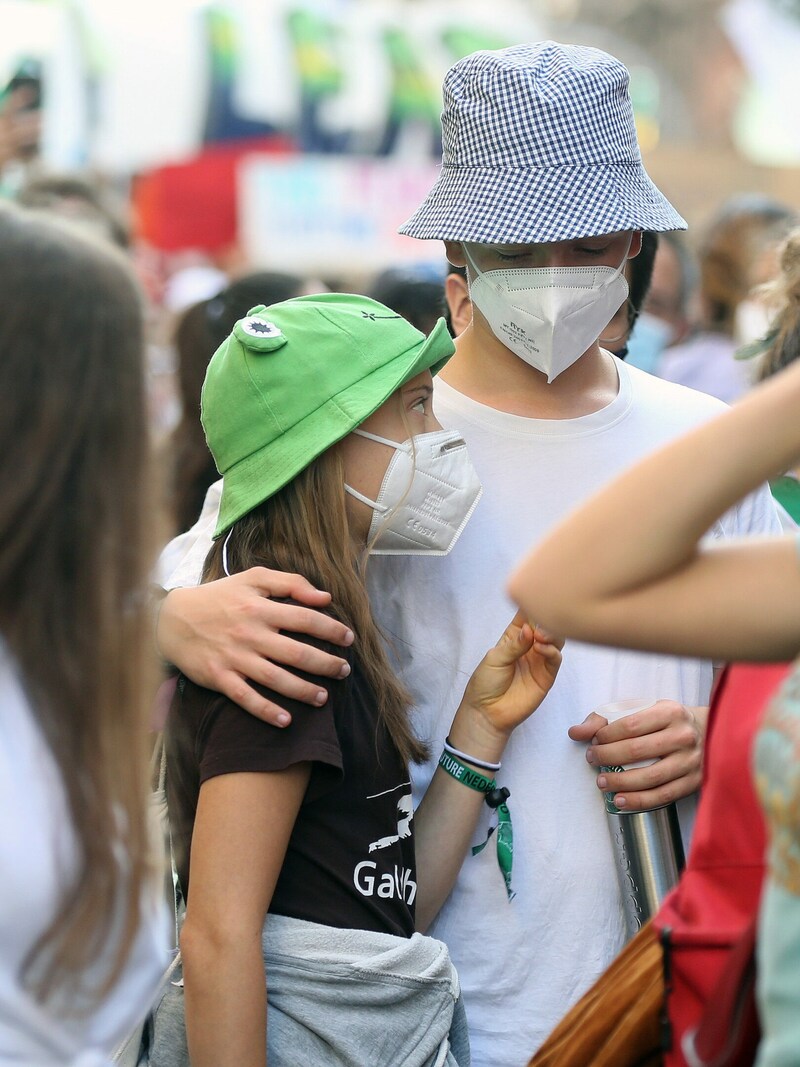 Der junge Mann mit kariertem Anglerhut legt den Arm um Greta Thunberg. (Bild: Claudio Veneroni / PA / picturedesk.com)