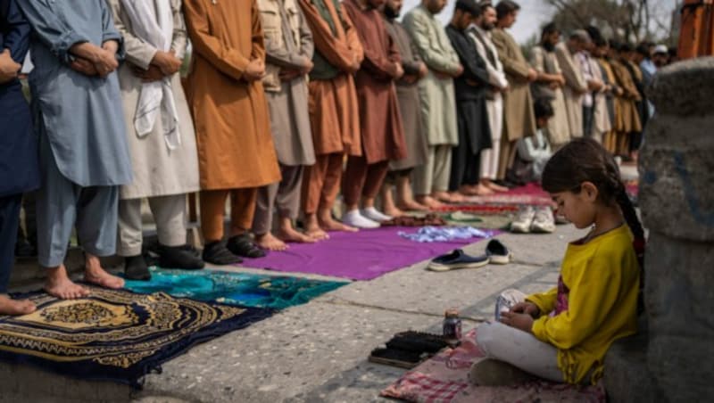 Ein Mädchen, das in Kabul als Schuhputzerin arbeitet, während des Freitagsgebets. (Bild: AP)