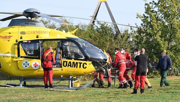 Lebensrettung ist Teamarbeit: Mit vereinten Kräften wird der Patient zum Helikopter getragen. (Bild: P. Huber)