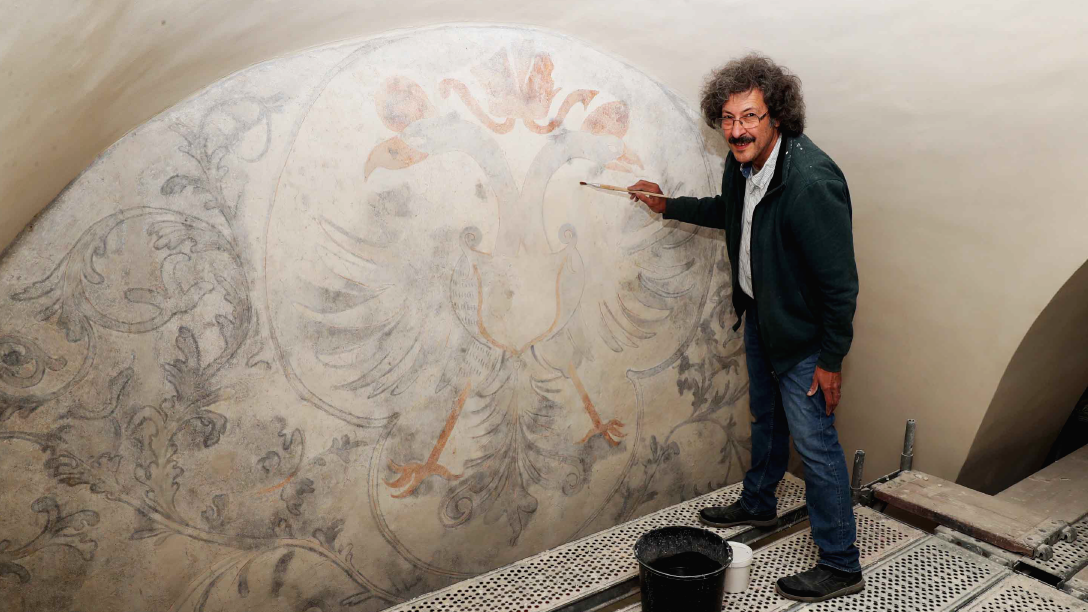 Restaurator Claudio Bizzarri konnte einen bemerkenswert großen Doppeladler auf der Schildwand zum Vorschein bringen. (Bild: Reinhard Judt)