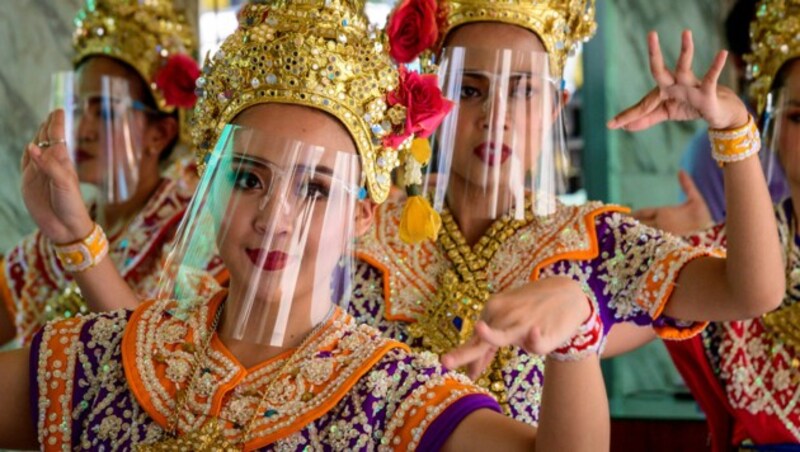 Traditionelle Tänzerinnen mit „Faceshield“ (Bild: Mladen ANTONOV / AFP)