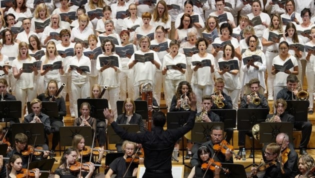 Das Orchester des Musikgymnasiums sowie hunderte Chorsänger in Weiß beim Festkonzert. (Bild: reinhard winkler 0699 81639929)