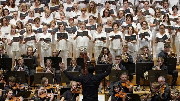 Das Orchester des Musikgymnasiums sowie hunderte Chorsänger in Weiß beim Festkonzert. (Bild: reinhard winkler 0699 81639929)