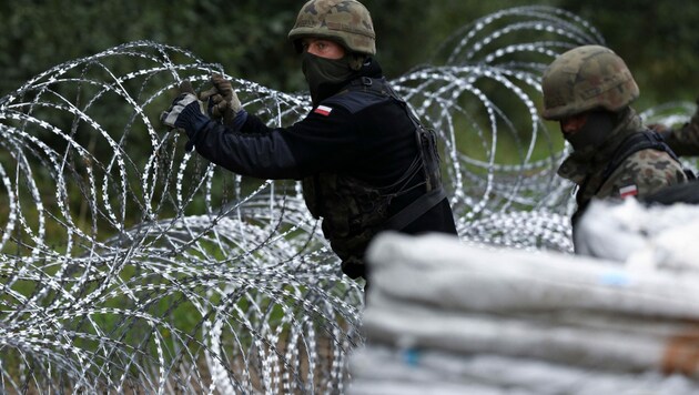 Polnische Soldaten beim Bau eines Zauns an der Grenze zu Weißrussland im August 2021 (Bild: AFP)