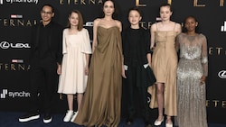 Angelina Jolies Tochter Zahara, rechts ganz außen, trug zur „Eternals“-Premiere ihrer Mutter deren Oscar-Kleid aus dem Jahr 2014. (Bild: APA/Photo by Jordan Strauss/Invision/AP)